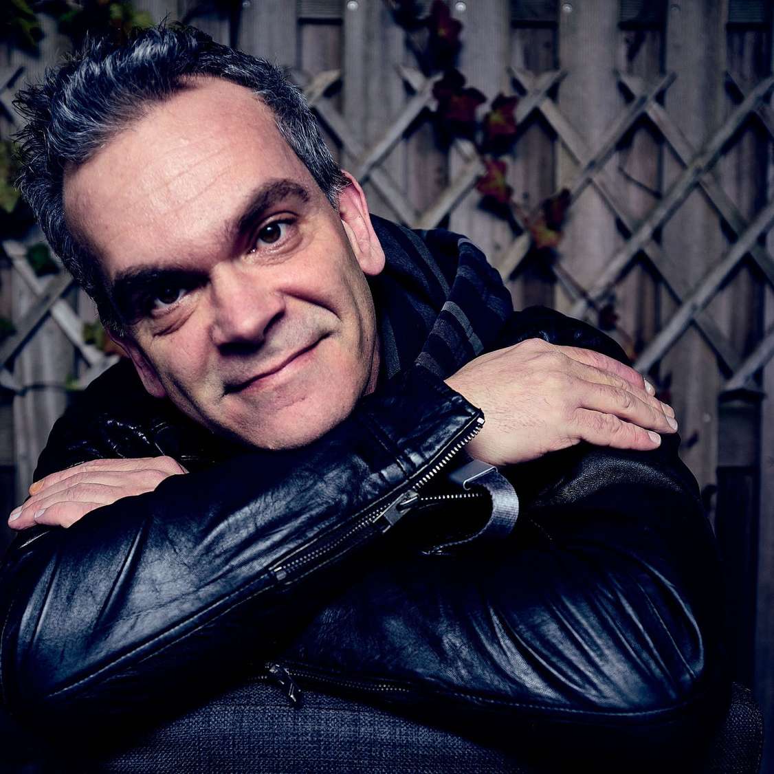 A headshot of Nils against a brick wall background.